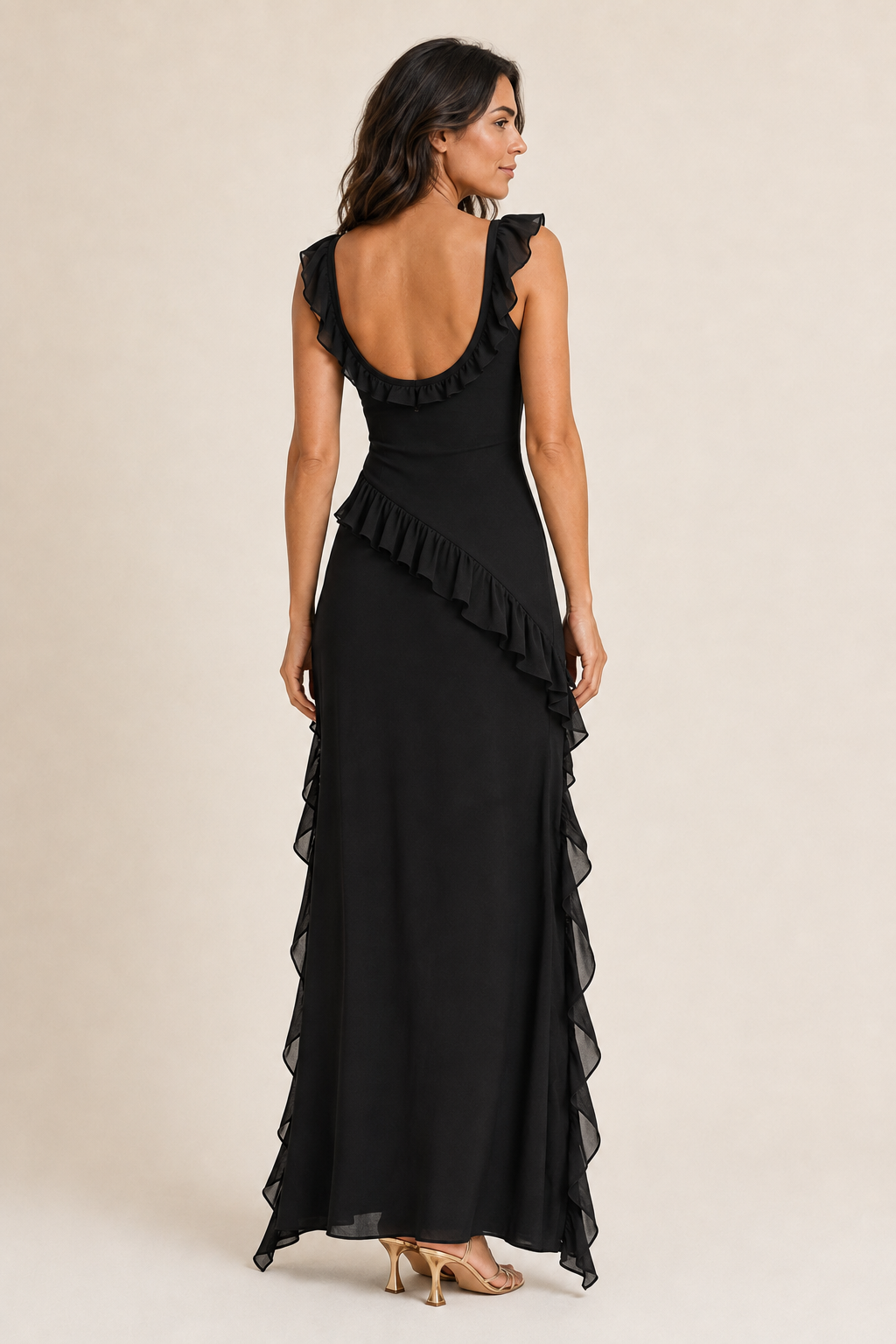 Back view of a woman wearing the black asymmetric ruffle maxi dress, showing the low back