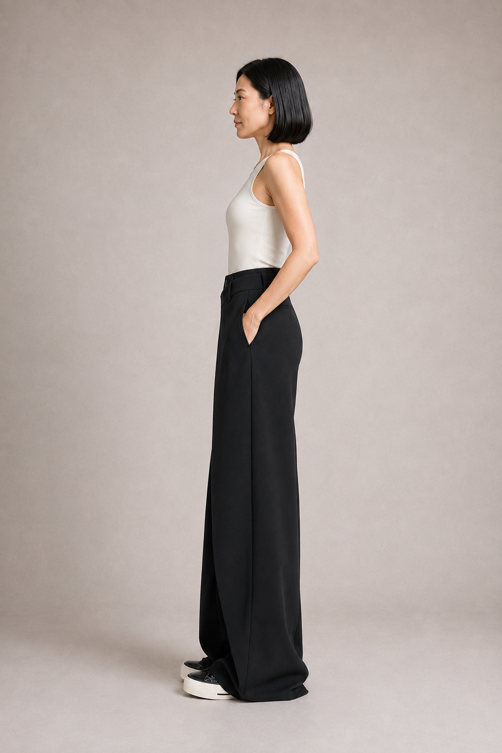 Right-side view of the black asymmetric-waist wide-leg trousers showing the side pocket and full-length drape