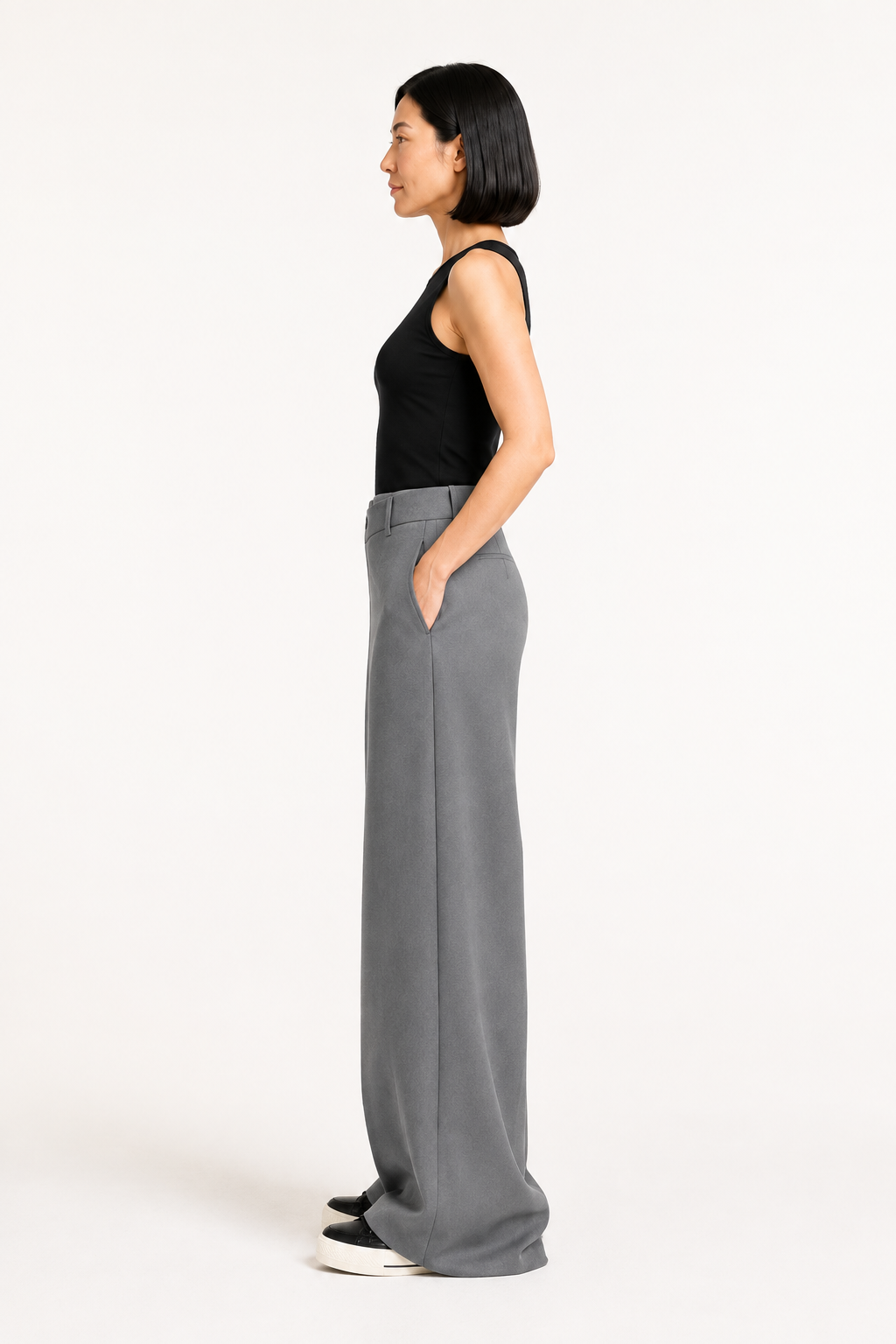 Right-side view of the grey asymmetric-waist wide-leg trousers showing the side pocket and full-length drape