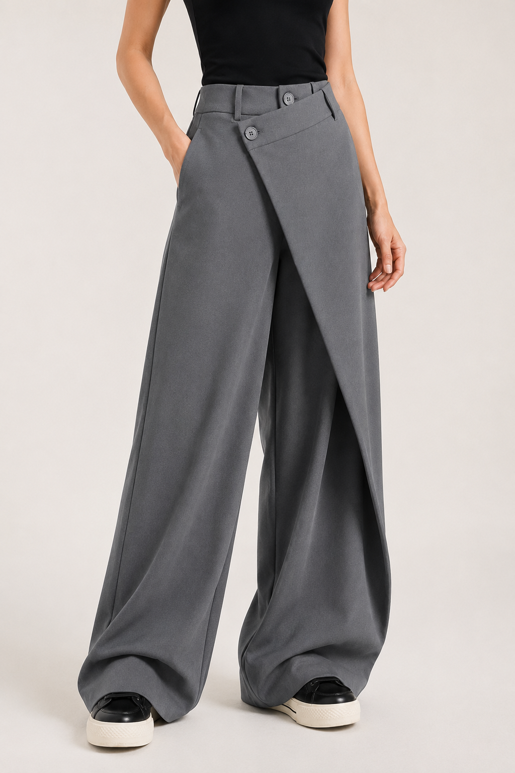 Right-side view of the grey asymmetric-waist wide-leg trousers showing the side pocket and full-length drape
