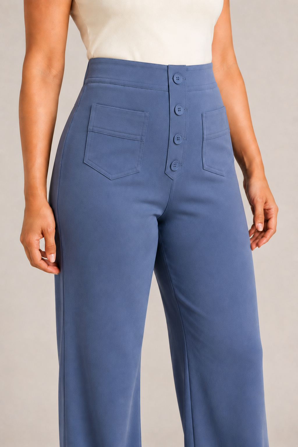 Model-worn close-up of the blue trousers showing the fine matte fabric texture and tonal stitching
