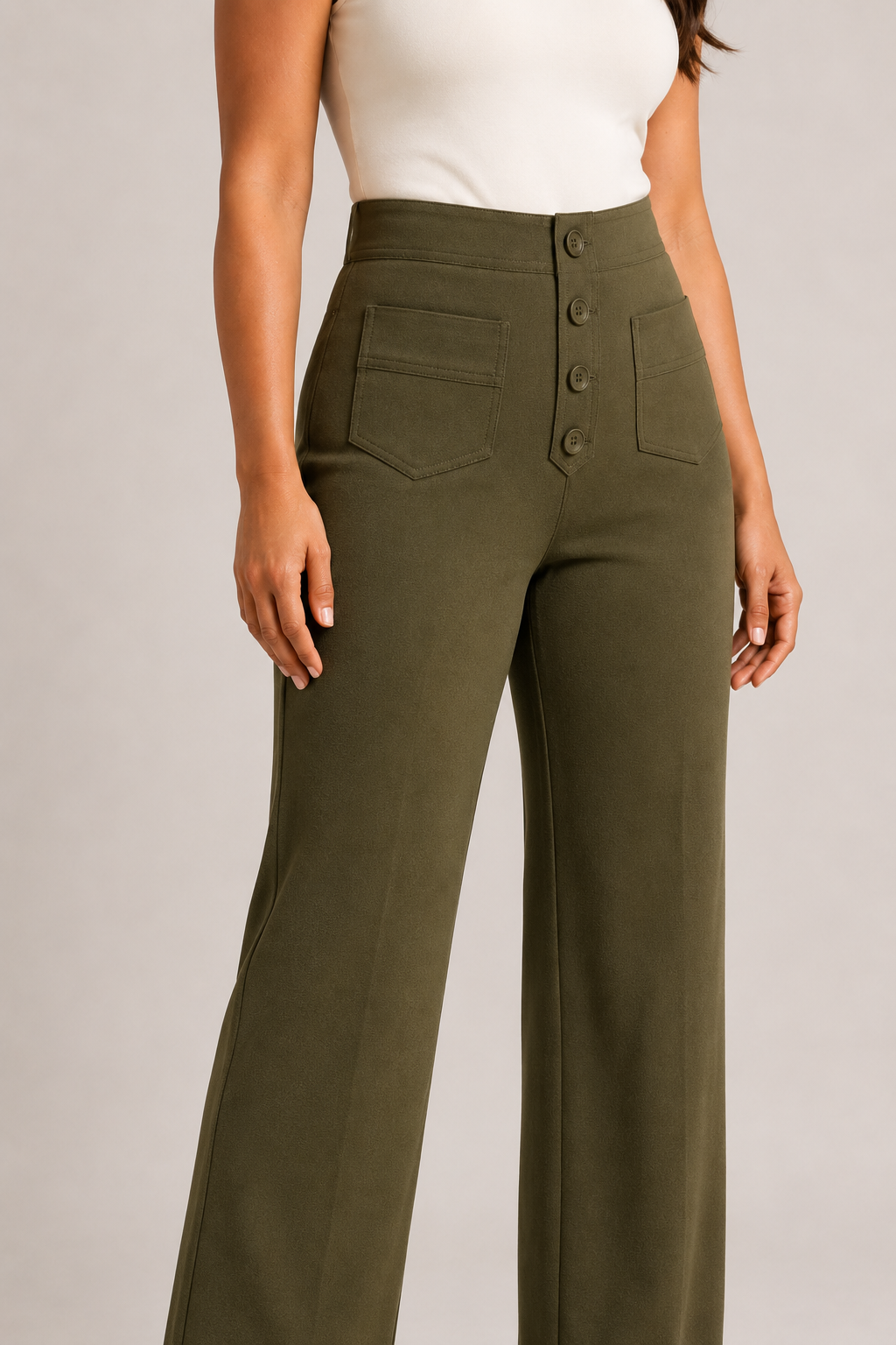 Model-worn close-up of the green trousers showing the fine matte fabric texture and tonal stitching