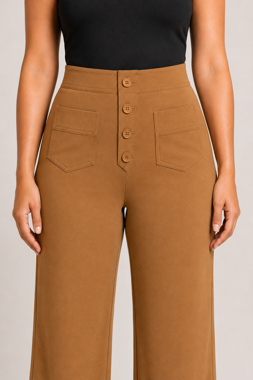 Close-up of the khaki trousers showing the four-button front placket, high waistband and patch pockets