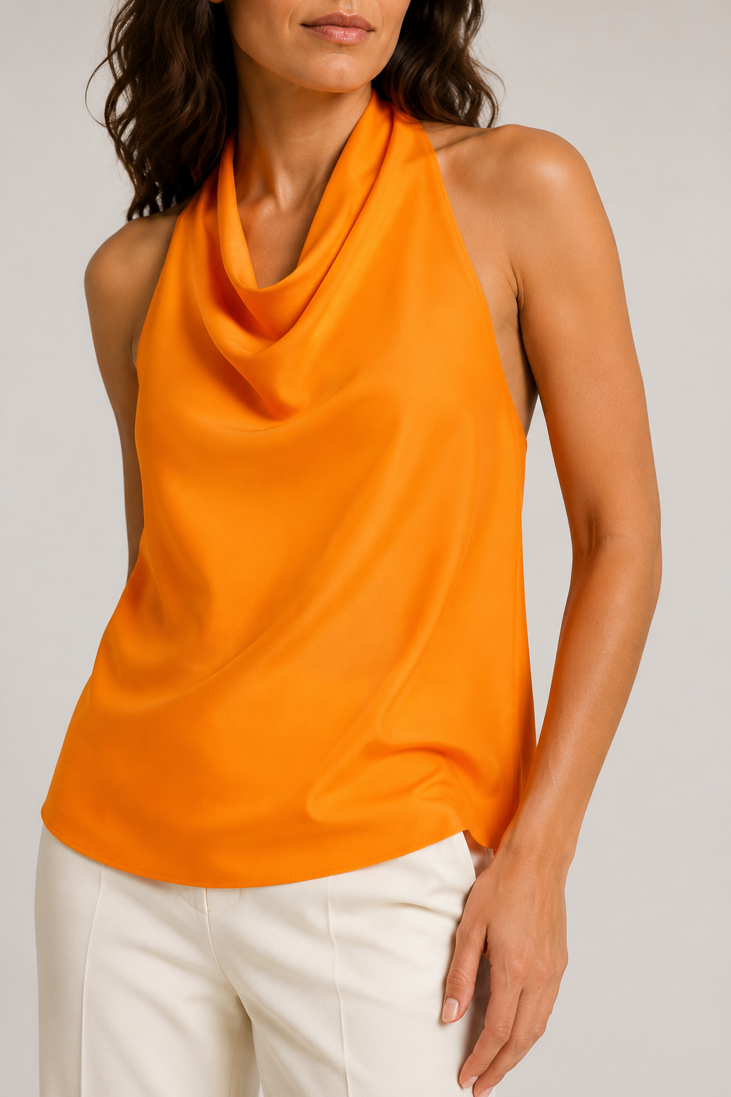 Model-worn close-up of the orange halter top showing the smooth lustrous fabric and cowl drape