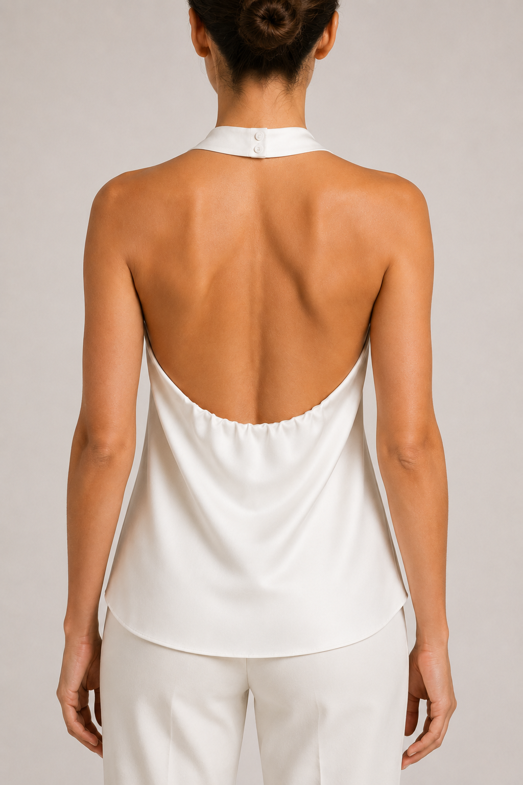 Back close-up of the white halter top showing the neck fastening, open back and gathered lower edge
