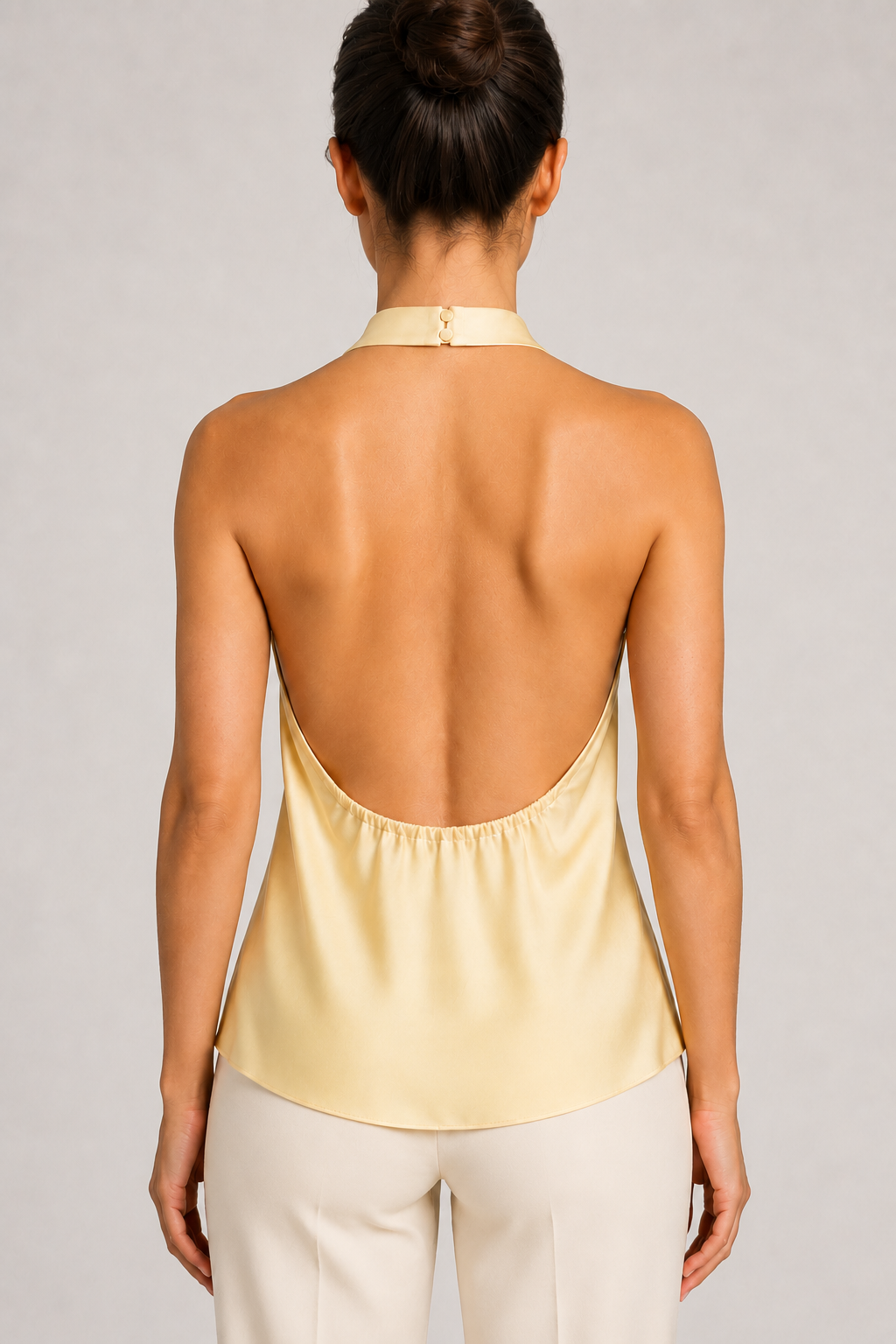 Back close-up of the yellow halter top showing the neck fastening, open back and gathered lower edge