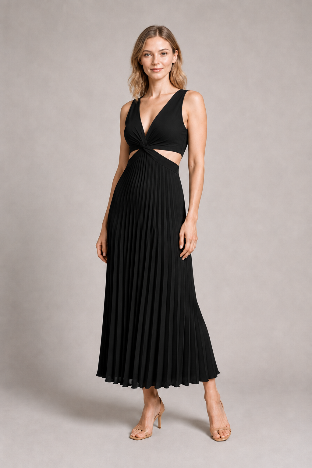 Woman wearing the black flowing pleated maxi dress, front three-quarter view