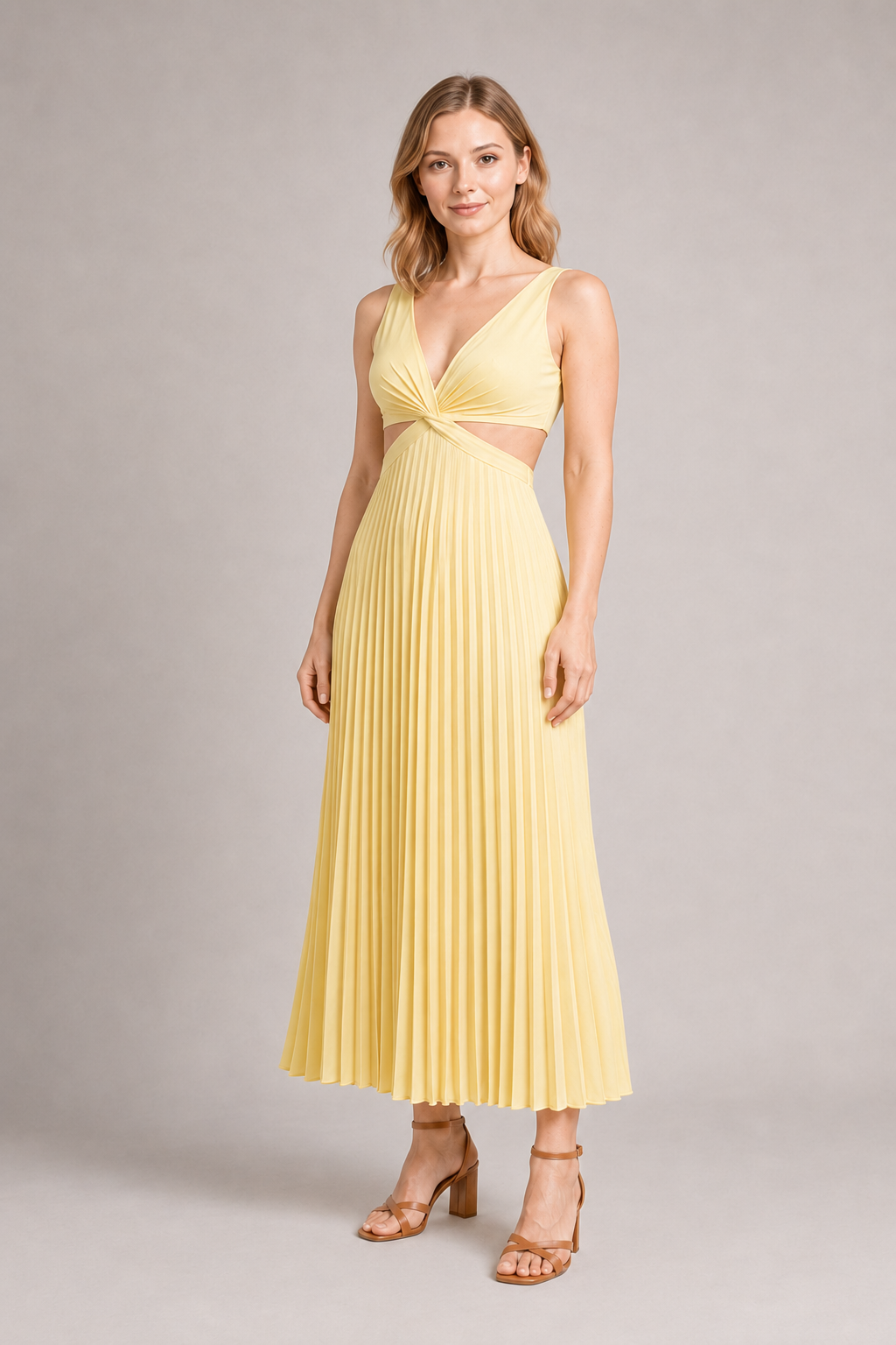 Woman wearing the yellow flowing pleated maxi dress, front three-quarter view