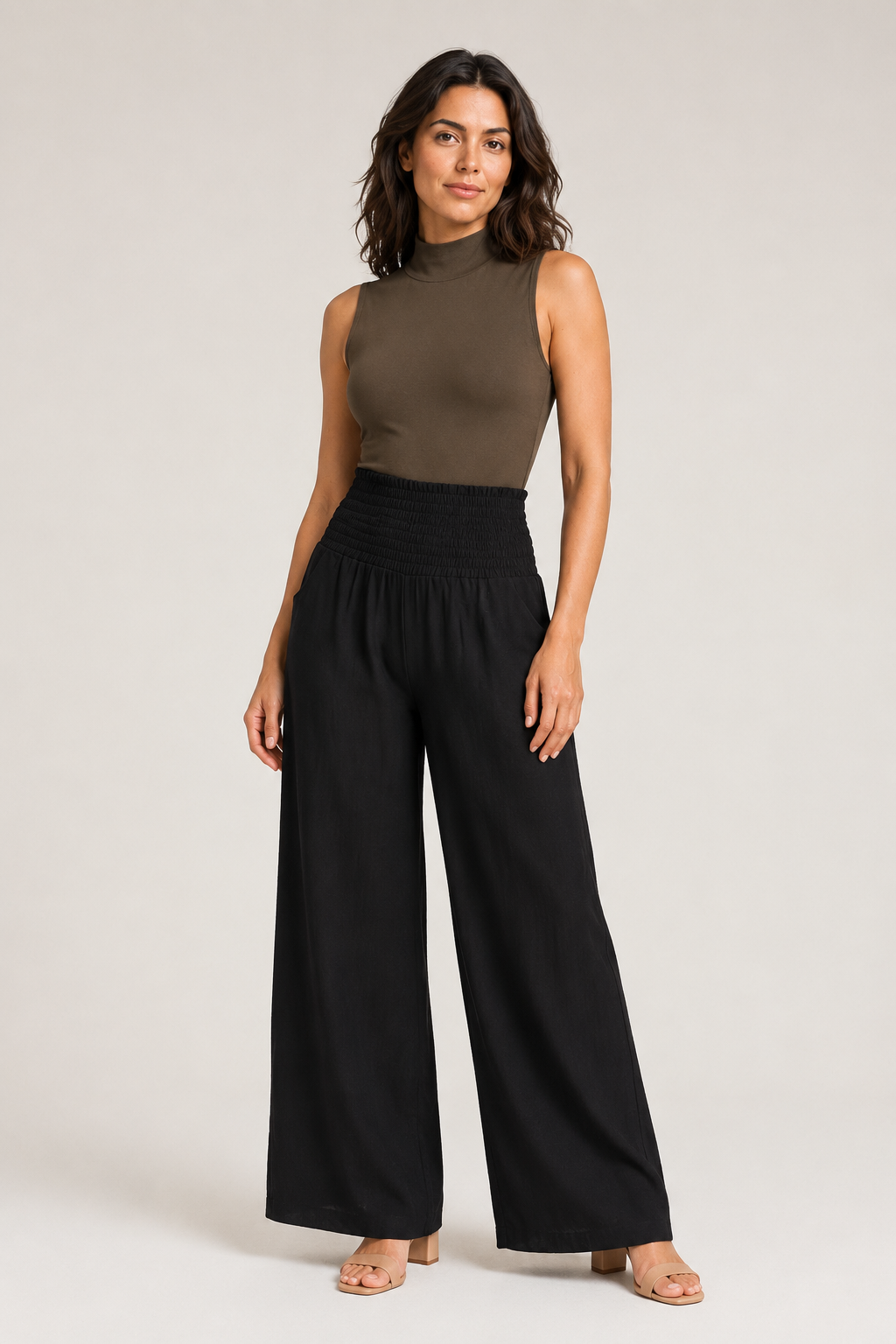 Woman wearing the black high-waisted palazzo trousers, front three-quarter view
