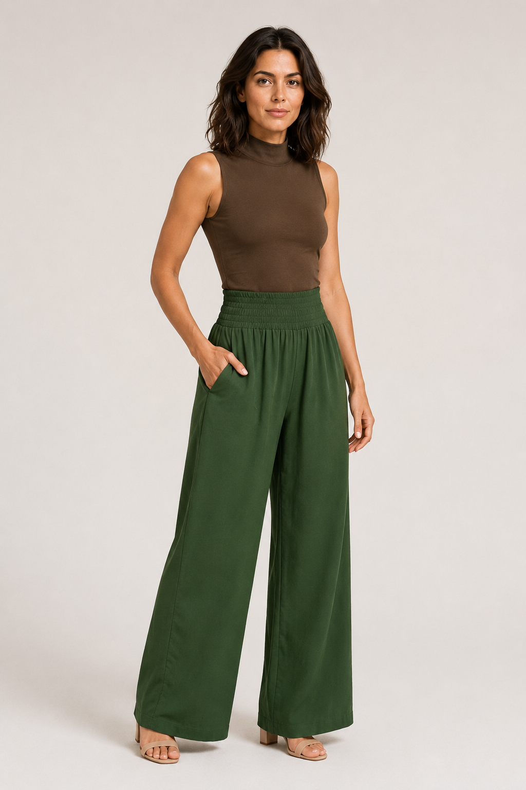 Woman wearing the green high-waisted palazzo trousers, front three-quarter view
