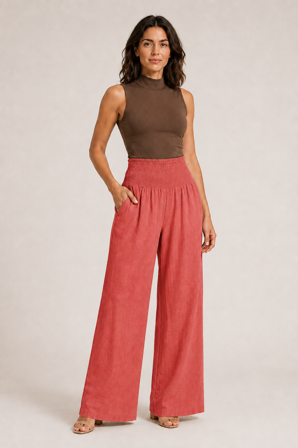 Woman wearing the orange-red high-waisted palazzo trousers, front three-quarter view