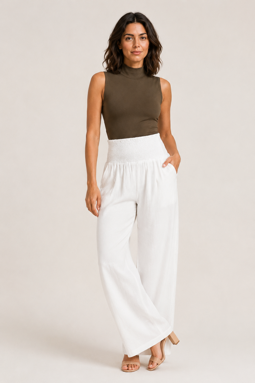 Woman wearing the white high-waisted palazzo trousers, front three-quarter view