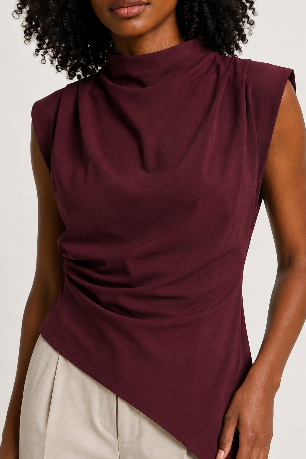 Burgundy sleeveless draped asymmetric top, model-worn fabric detail