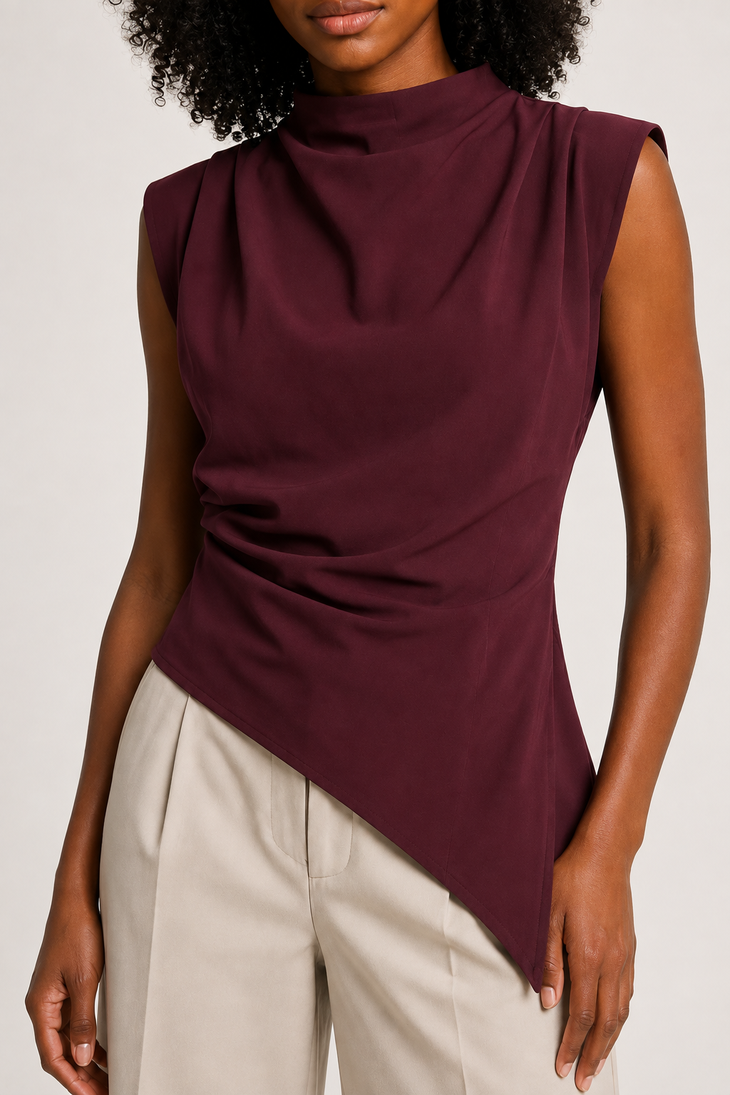 Burgundy sleeveless draped asymmetric top, ruched waist and asymmetric hem construction detail